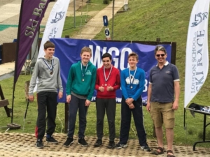 4 students and teacher at base of dry ski slope with medals