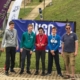 4 students and teacher at base of dry ski slope with medals