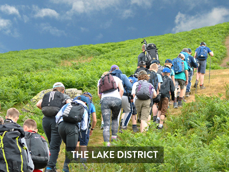 large group of students walk up hill. caption reads 'the lake district'