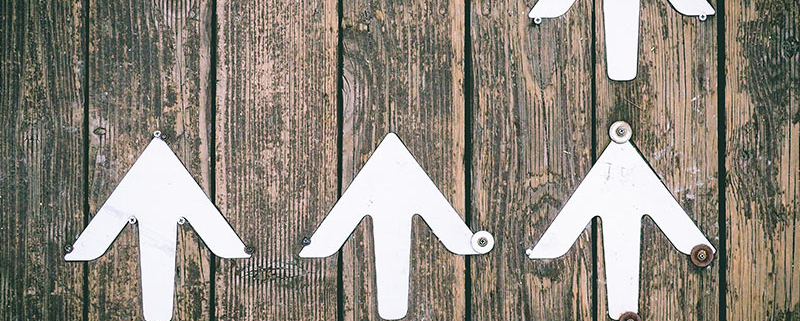 5 upward-facing arrows nailed to wooden board
